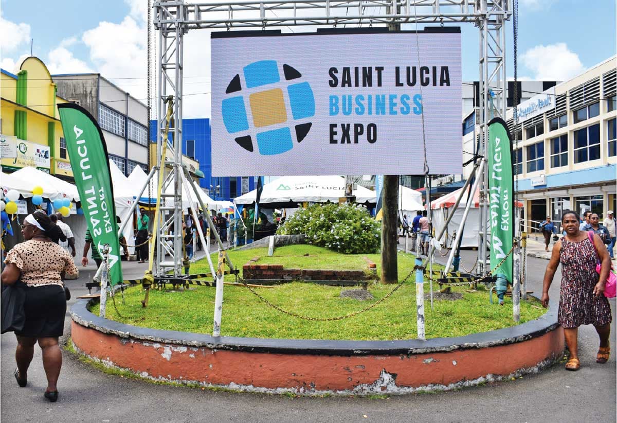 Saint Lucia Business sign with locals walking around it in the heart of the business center